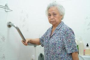Aziatische senior of bejaarde oude dame vrouw patiënt gebruik helling loopbrug handvat beveiliging met hulp ondersteuning assistent in verpleeg ziekenhuisafdeling