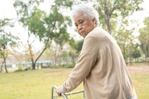 Aziatische senior of oudere oude dame vrouw patiënt lopen met rollator in park met kopieerruimte foto