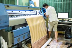 technicus vult inktkleur van inkjetprinter bij tijdens het afdrukken van kaartsticker foto