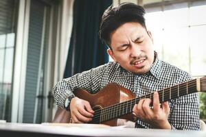 Aziatisch mannetje musicus spelen gitaar in opname studio. spelen leven muziek- akoestisch muziek- of klassiek muziek- genre. solo artiest. componist foto