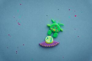 plasticine 3d ufo, ruimteschip beeldhouwwerk, schattig groen buitenaards wezen Aan sterrenhemel achtergrond foto