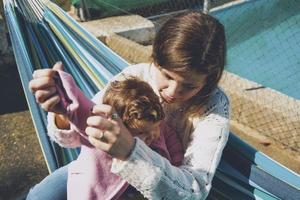 jonge vrouw die haar baby geeft zittend op een hangmat foto