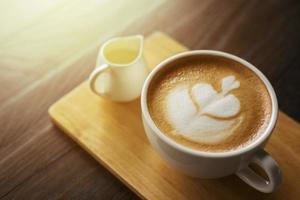 hete latte art op houten tafel foto