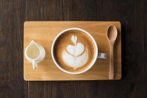 hete latte art op houten tafel foto