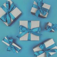 geschenkdozen verpakt in ambachtelijk papier met blauwe linten en strikken. feestelijk zwart-wit plat leggen.
