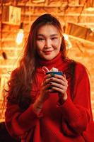 Aziatisch meisje met mok warme chocolademelk. foto