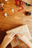 vrouwenhanden binden lint op kerstcadeau foto