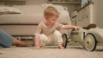 gelukkig familie Bij huis. baby jongen spelen met speelgoed Bij huis binnenshuis. weinig kleuter kind en moeder hebben pret samen. kind zoon rust uit in leven kamer. foto