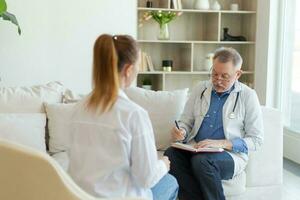 senior Mens dokter onderzoeken yound vrouw in dokter kantoor of Bij huis. meisje geduldig en dokter hebben overleg in ziekenhuis kamer. geneeskunde gezondheidszorg medisch controle. bezoek naar dokter. foto