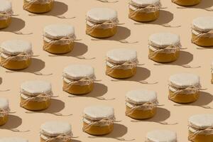 patroon van glas pot met honing onder kraft papier Aan een draad Aan beige achtergrond. zoet voedsel monochroom concept. foto