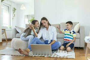 weinig ondeugend kinderen afleidend bezig jong vrouw van werk Aan laptop Bij huis foto