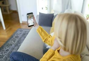 dichtbij omhoog van een jong vrouw pratend naar haar dokter Aan een video telefoontje foto