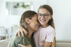 liefhebbend jong moeder lachend omarmen glimlachen schattig grappig kind dochter genieten van tijd samen Bij huis, gelukkig familie single mam met weinig kind meisje hebben pret spelen voelen vreugde knuffelen en knuffelen foto