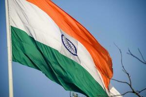 indiase vlag hoog op connaught plaats met trots in blauwe lucht, indiase vlag wapperen, indiase vlag op onafhankelijkheidsdag en republiek dag van india, tilt-up shot, wuivende indische vlag, har ghar tiranga foto