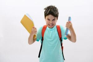 verward boos schooljongen Holding studieboeken, uitdrukken woede, irritatie en frustratie, geïsoleerd Aan wit achtergrond foto