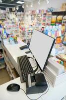 aanrecht in schrijfbehoeften winkel met wit blanco pc monitor, contant geld teller machine, credit kaart lezer en streepjescode scanner foto