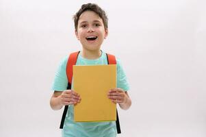 emotioneel gelukkig tiener- school- jongen Holding studieboeken, glimlachen op zoek Bij camera, staand over- wit geïsoleerd achtergrond foto