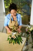 bloemist creëren een bloem arrangement met vers orchidee bloemen en planten, invoegen een verjaardag kaart, in bloemen winkel foto