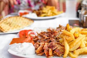 Griekse gyros op een bord met frietjes en groenten foto