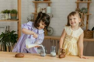 weinig gelukkig meisjes dwaas in de omgeving van in de voorjaar en koken in de keuken foto