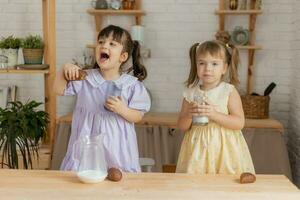 weinig gelukkig meisjes dwaas in de omgeving van in de voorjaar en koken in de keuken foto