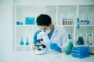 mannetje wetenschapper onderzoeker dirigeren een experiment werken in chemisch laboratorium foto