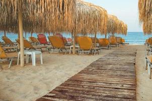 strand met ligstoelen en parasols foto