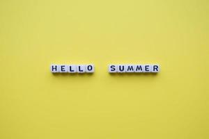 hallo zomer woord kubussen, op een gele achtergrond. foto