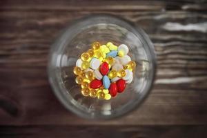 plat glas met kleurrijke vitamines en pillen erin.