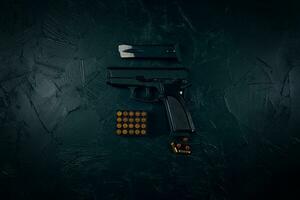 pistool met patronen op donkere betonnen tafel. foto