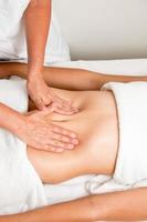 massagetherapeut die de maag van een vrouw masseert foto