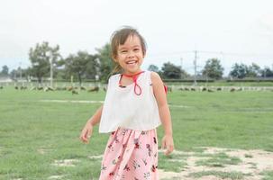 gelukkig kind meisje plezier in schapenboerderij. foto