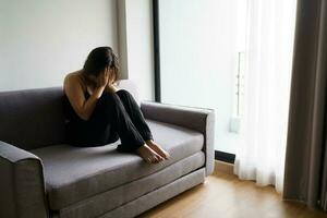 verdrietig vrouw denken over problemen zittend Aan een sofa van streek meisje gevoel eenzaam en verdrietig van slecht verhouding of depressief vrouw wanorde mentaal Gezondheid. foto