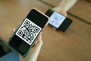 qr code betaling. vrouw scannen qr code online boodschappen doen zonder contant geld technologie concept. foto