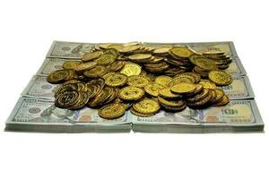 stapel gouden munten en geld bankbiljet 100 usd foto