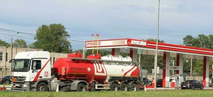 Sankt petersburg Rusland - 07 13 2023 stationair levering vrachtauto lukoil leveren, vulling de benzine tanks in benzine station lukoil foto