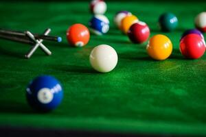 man's hand- en keu arm spelen snooker spel of voorbereidingen treffen het richten naar schieten zwembad ballen Aan een groen biljart tafel. kleurrijk snooker ballen Aan groen fries. foto