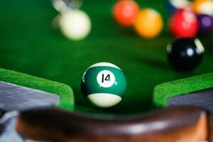 man's hand- en keu arm spelen snooker spel of voorbereidingen treffen het richten naar schieten zwembad ballen Aan een groen biljart tafel. kleurrijk snooker ballen Aan groen fries. foto