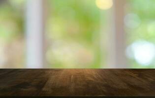 leeg donker houten tafel in voorkant van abstract wazig bokeh achtergrond van restaurant . kan worden gebruikt voor Scherm of montage uw producten.mock omhoog voor ruimte. foto