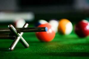 man's hand- en keu arm spelen snooker spel of voorbereidingen treffen het richten naar schieten zwembad ballen Aan een groen biljart tafel. kleurrijk snooker ballen Aan groen fries. foto