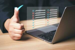 zakenman werken Aan laptop computer produktiviteit checklist en vulling enquête het formulier online, document beheer systeem dms. beoordeling het formulier, vragenlijst, checklist en klembord taak beheer. foto