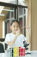 weinig kind met aan het leren wetenschap klasse in school- laboratorium foto