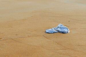 plastic zak zijn links Aan de strand net zo verspilling vervuilend natuur, plastic is moeilijk naar degraderen, vernietigen de ecosysteem, wereld milieu dag concept. vuilnis morsen Aan strand foto