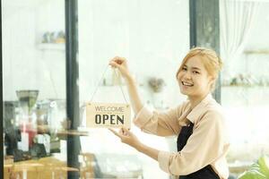 jong bedrijf eigenaar Open de koffie winkel. foto