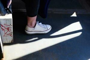 foto van wit sportschoenen Aan vrouw been tegen