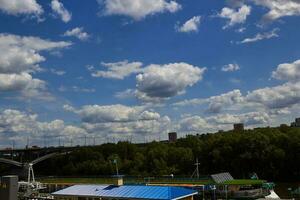 blauw lucht met wolken brug over- rivier- bomen. foto