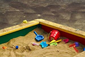 plastic kinderen speelgoed in zandbak Bij speelplaats. foto