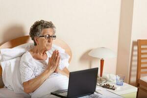 oud vrouw is communiceren door haar computer verstand familieleden foto