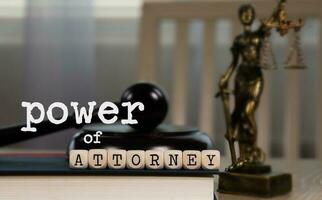 woorden macht van advocaat samengesteld van houten dobbelstenen. houten hamer en standbeeld van themis in de achtergrond. foto