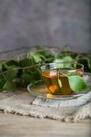 berk blad trein een glas kop Aan een houten oppervlak. foto